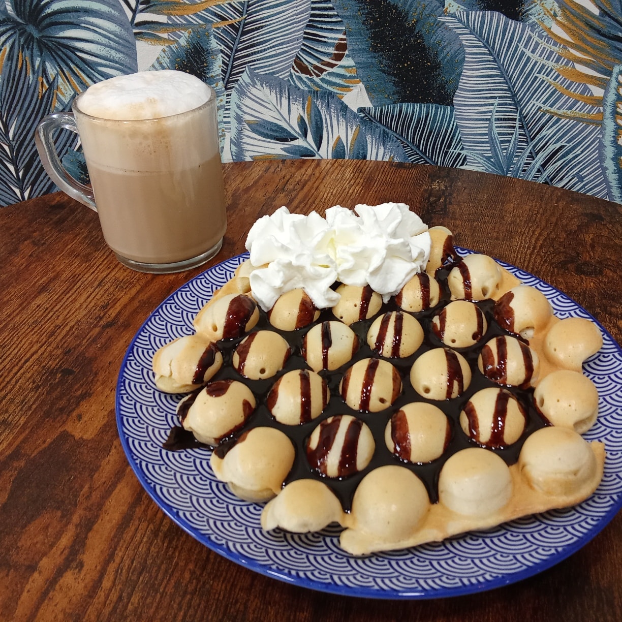 Bubble waffle au chocolat et cappuccino chez Festi Douceurs à Villefranche-de-Lauragais sur table bois décor bleuté,